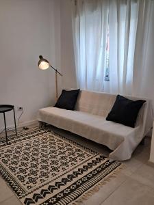 a couch sitting in a living room with a rug at Casa do Rio - Apartment Earth in Portimão +7 photos