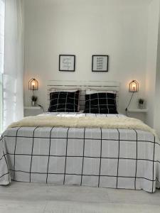 ein weißes Schlafzimmer mit einem großen Bett mit zwei Lampen in der Unterkunft Gare - Les Champs - Parking Privé in Saint-Brieuc