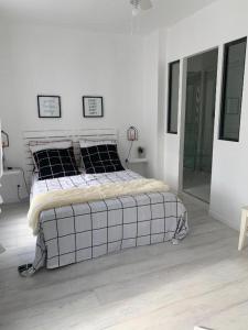 ein Schlafzimmer mit einem Bett in einem weißen Raum in der Unterkunft Gare - Les Champs - Parking Privé in Saint-Brieuc