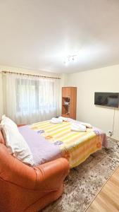 ein Schlafzimmer mit einem großen Bett und einer Couch in der Unterkunft ARIA HOUSE Sinaia in Sinaia