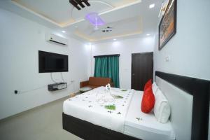a hotel room with a bed and a tv at THE HOTEL PARADISE in Gorakhpur +8 photos