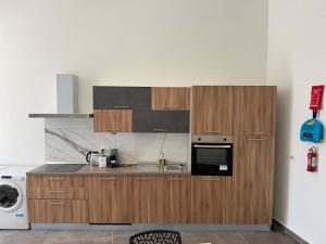 a kitchen with wooden cabinets and a sink at Family 2BR Apartment in Fgura - by HostMT in Taʼ Penza