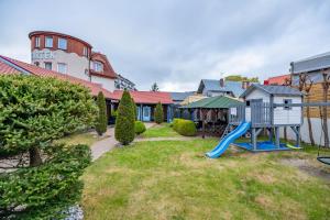 a yard with a slide and a playground at Baltic Apartment Rewal - Bartek Domki in Rewal