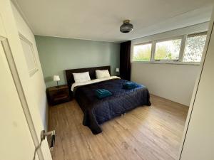 a bedroom with a bed in a room with a window at Holiday Home de Binnengouw in Hoogwoud