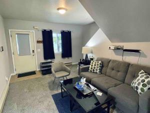 una sala de estar con un sofá y una mesa en Downtown 2BR Gem: Near Soaring Eagle & Downtown, en Mount Pleasant