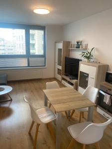 a living room with a wooden table and chairs at CityPark Apartment, free parking & AC in Bratislava