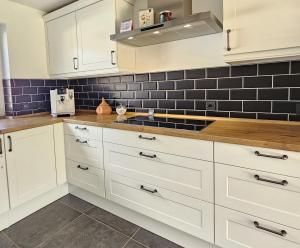 a kitchen with white cabinets and a sink at Private room`s Aitrach, style, comfort, Quiet, motorway connection in Aitrach