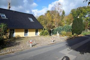 ein gelbes Haus am Straßenrand in der Unterkunft Ferienhaus für 3 Personen  2 Kinder ca 60 m in Neuenkirchen, Ostseeküste Deutschland Rügen in Neuenkirchen