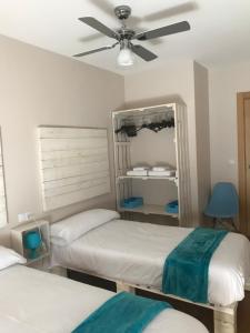 Un dormitorio con dos camas y un ventilador de techo. en Apartamento Turístico “El Yugo”, en Arguedas