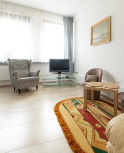 イェレニャ・グラにあるApartament Grodzka Centrumの椅子2脚とテレビのあるリビングルーム