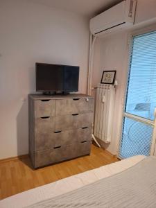 1 dormitorio con vestidor y TV de pantalla plana. en Апартамент за нощувки Марго, en Burgas