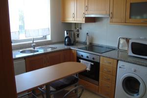 a kitchen with a sink and a stove top oven at Vila Branca in Mosqueira