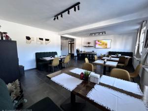 ein Restaurant mit Tischen und Stühlen und einem Speisesaal in der Unterkunft Nort Inn - Luncile Prigoanei, Sureanu, Oasa, Transalpina in Tău Bistra