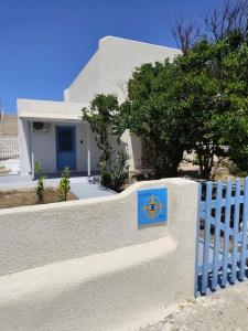 a white fence with a sign on it in front of a house at North eye in Apollon