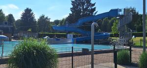 哈勒Ferienhaus für max6Gäste 2Kids 4Erwn的公园内的水滑梯,游泳池