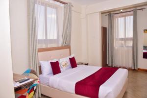 NarokWalabi Mara Hotel的卧室里有一张大床，配有红色枕头 更多37张照片