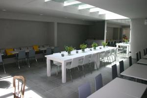 een grote kamer met tafels en stoelen met planten erop bij Vizion Suites by CELTIS in Carilo