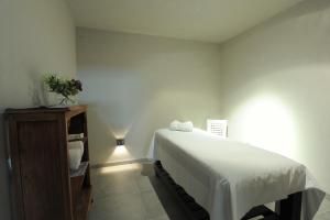 een slaapkamer met een wit bed en een houten kast bij Vizion Suites by CELTIS in Carilo +5 foto's