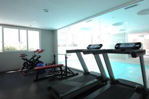 een fitnessruimte met 2 loopbanden en een zwembad bij Vizion Suites by CELTIS in Carilo