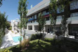 een appartementencomplex met een zwembad en bomen bij Vizion Suites by CELTIS in Carilo