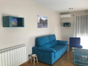 Un sofá azul en una sala de estar. en Apartamento Turístico “El Yugo”, en Arguedas