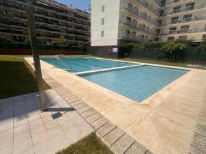 an empty swimming pool in front of a building at Apartamento Malgrat de mar in Malgrat de Mar