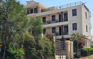 NarokWalabi Mara Hotel的一栋白色建筑，前面有树
