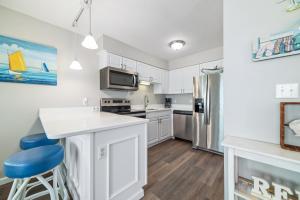 eine Küche mit weißen Schränken und einem blauen Stuhl in der Unterkunft Perdido Skye 16 in Pensacola