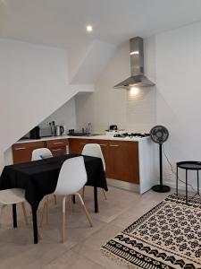 a kitchen with a table and chairs and a stove at Casa do Rio - Apartment Earth in Portimão