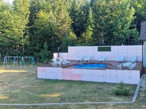 un cortile con piscina e parco giochi di Vila Tri Srca a Beserovina