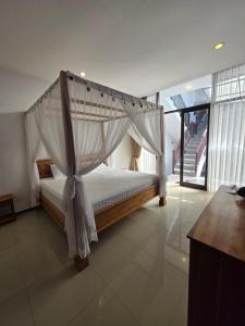 a bedroom with a canopy bed in a house at Serenity Nirvana Palace -Private Rooms & Suitable for families Jimbaran in Jimbaran