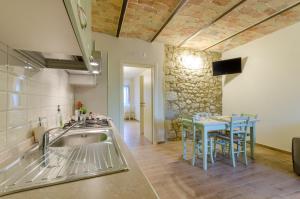 a kitchen with a sink and a table with chairs at Agriturismo Tenuta Umberto I in Ripacorbaria