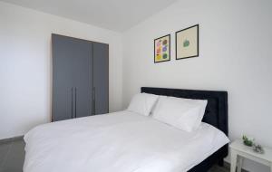 1 dormitorio con 1 cama blanca y armario negro en The most special 3-BDR on Achziv, en Nahariyya 7 fotos más