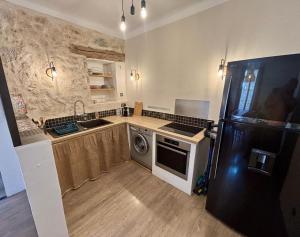 a kitchen with a refrigerator and a sink and a dishwasher at Loft avec balcon in Cotignac