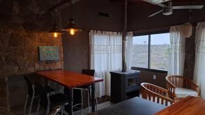 a living room with a table and a wood stove at Cabaña Casa Flor Bru in Villa Yacanto