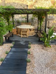 a patio with a table and benches under a pergola at Casa Luna in La Drova