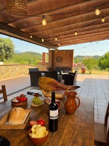 a table with food and a bottle of wine on a patio at Ca l'Esclatat in Santa María de Palautordera