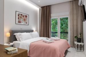 a bedroom with a bed with a pink blanket at THELIA Sofouli Urban Living in Thessaloniki