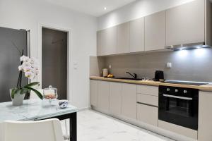 a kitchen with white cabinets and a black stove at THELIA Sofouli Urban Living in Thessaloniki