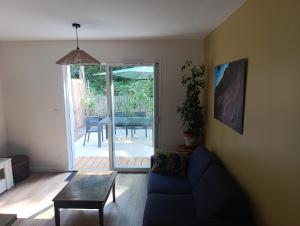 a living room with a blue couch and a table at Lisière Hébergements - Casa Mouette Mouette in La Tremblade