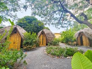 a group of huts with tables and chairs in a garden at Samui Circus Studio & Ville - Dome Bungalow 1 in Amphoe Koh Samui +15 photos