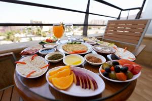 a table with plates of food and glasses of orange juice at Mass Plaza Hotel in Aqaba