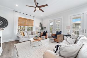 Il comprend un salon doté d'un mobilier blanc et d'un ventilateur de plafond. dans l'établissement Mer Soleil, à Orange Beach 63 autres photos