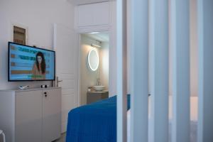 a bedroom with a flat screen tv and a bed at Petite maison in Itea