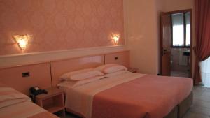 a hotel room with two beds and a window at Hotel Lanterna in Porto San Giorgio