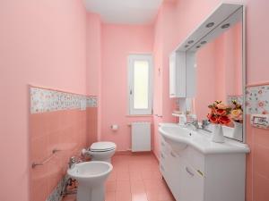 une salle de bains rose avec toilettes et lavabo. dans l'établissement Villa dei Fiori - Exclusive Villa with garden in Sorrento Coast, à Vico Equense 69 autres photos