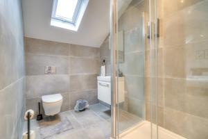 a bathroom with a toilet and a glass shower at Luxury Penthouse Flat Manchester in Wythenshawe