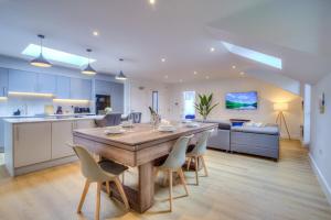 a kitchen and living room with a wooden table and chairs at Luxury Penthouse Flat Manchester in Wythenshawe