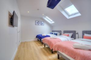 three beds in a room with skylights at Luxury Penthouse Flat Manchester in Wythenshawe