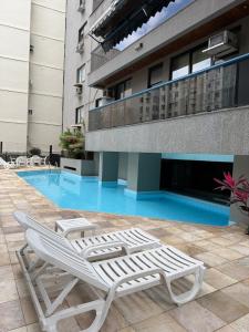 a pair of lounge chairs sitting in front of a building at Apartamento em Copacabana in Rio de Janeiro